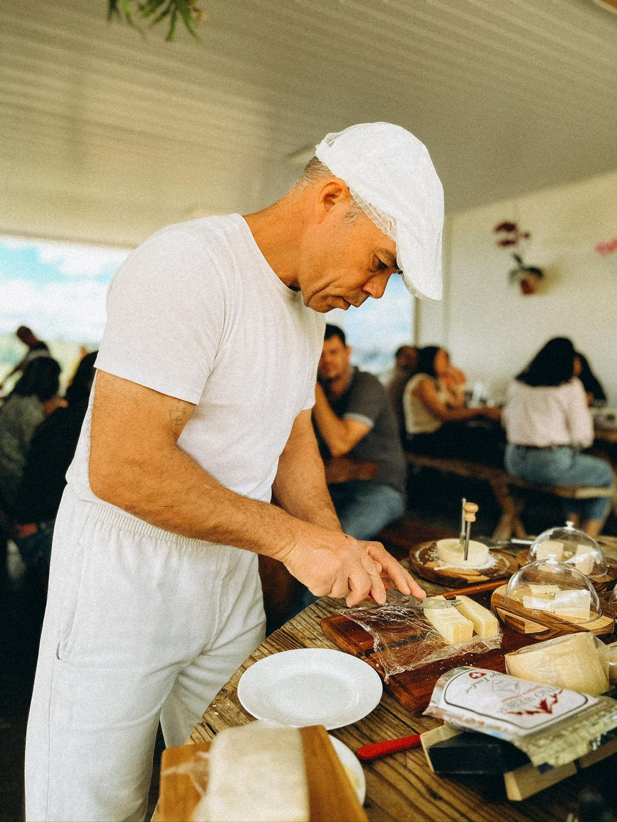 Tino Weber cortando queijo durante uma degustação na propriedade